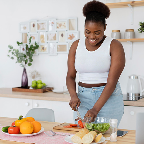 Lady cutting a tomato for a healthy lifestyle